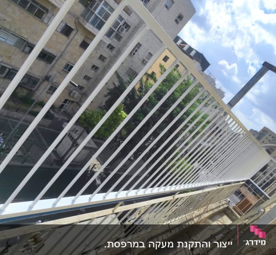 מעקה מתכת לבן עם סורגים אנכיים
